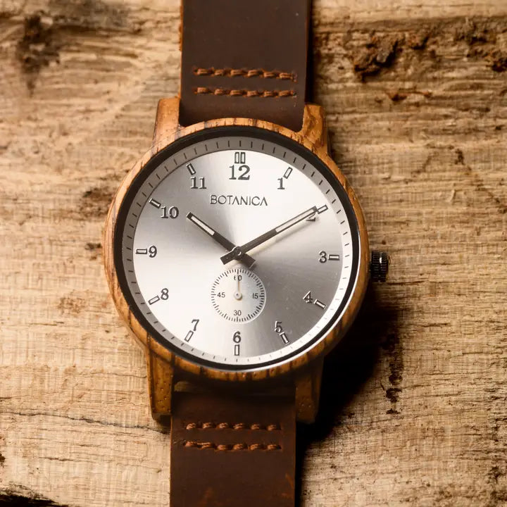 Wooden watch with brown leather strap on a wooden surface