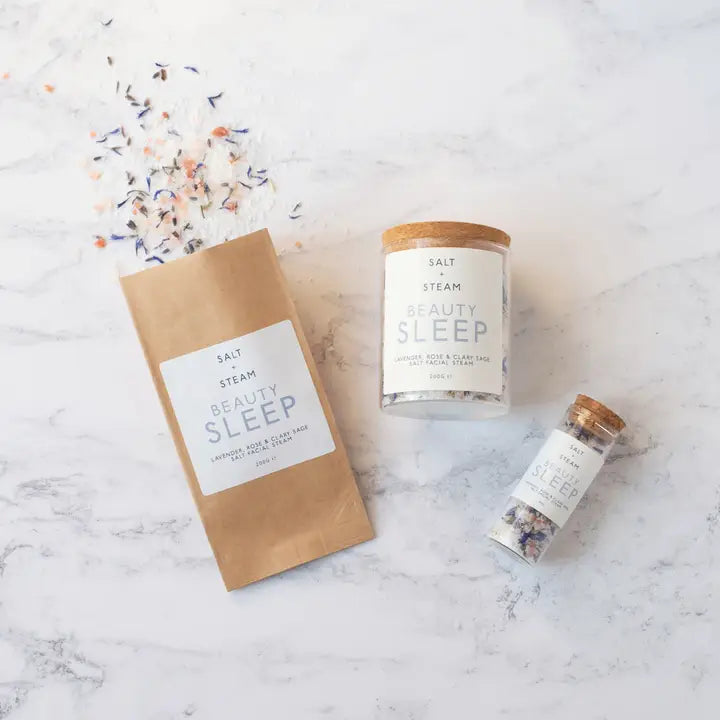 Three 'Salt & Steam Beauty Sleep' products on a marble surface