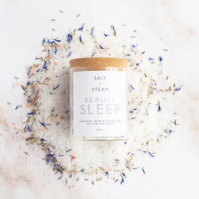 Salt and Steam Beauty Sleep salt facial scrub with a wooden lid on a white background