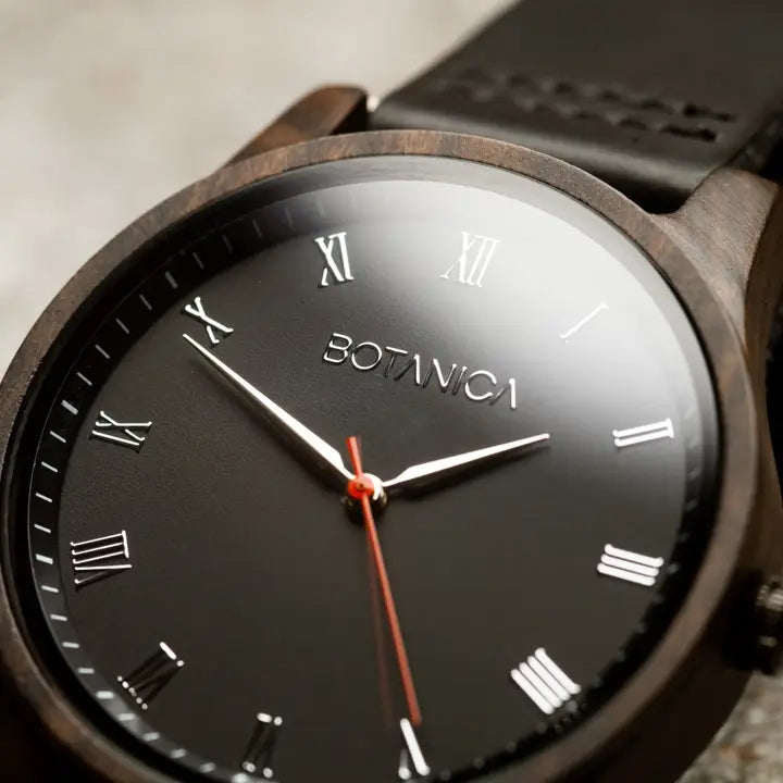 Watch with black dial and wooden strap featuring the brand 'BOTANICA'.