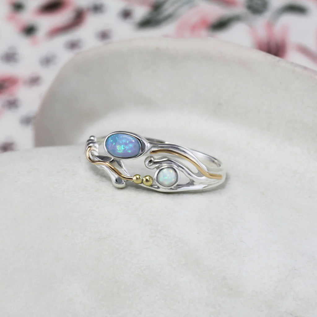 Silver ring with opal stones on a white background