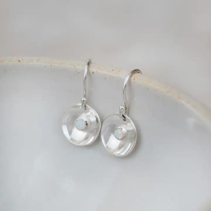 Silver earrings with opal stones on a light gray background