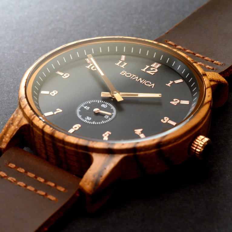 Wooden watch with a dark face and gold accents on a black background
