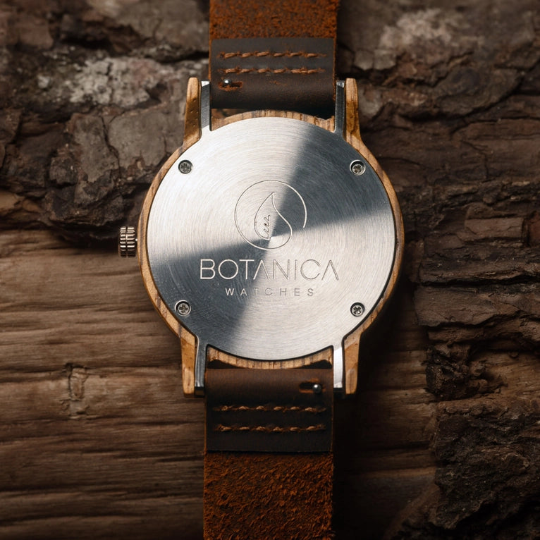Wooden watch with brown leather strap on a stone background