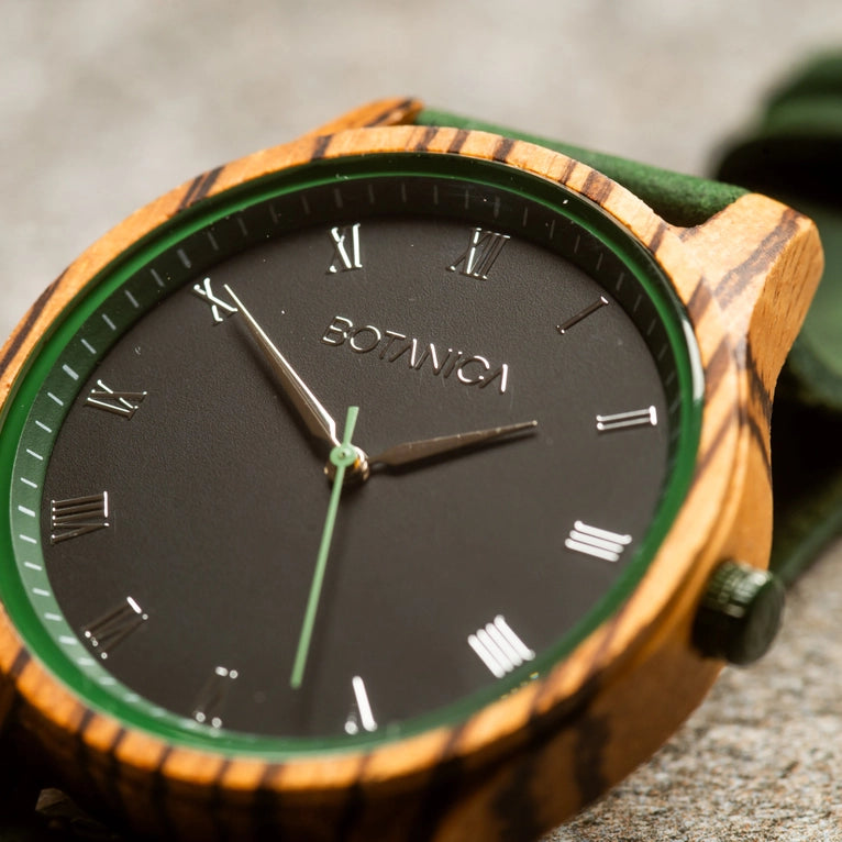 Wooden watch with black dial and Roman numerals on a textured surface